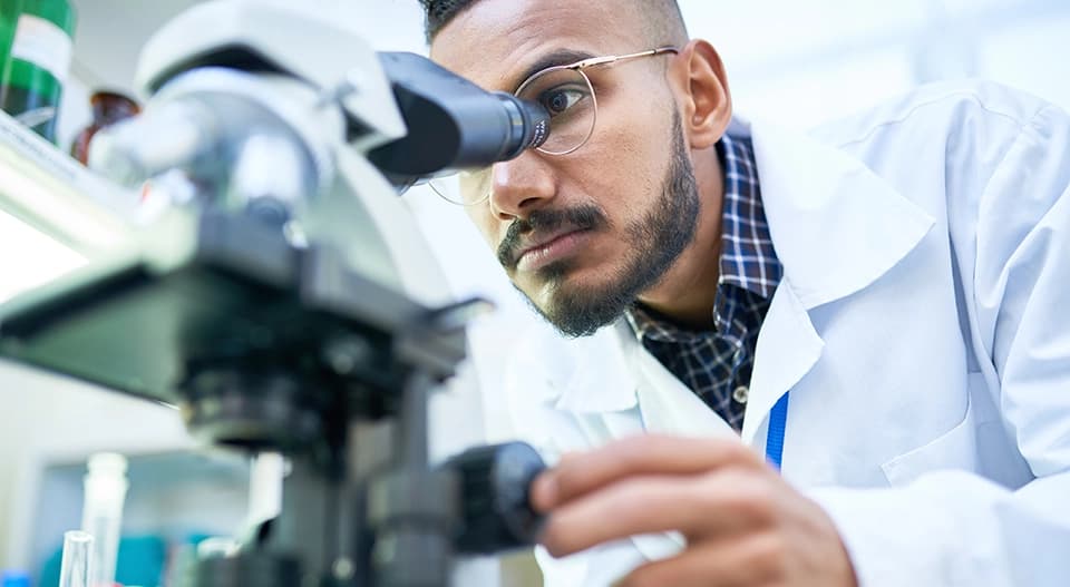 Scientist looking through microscope